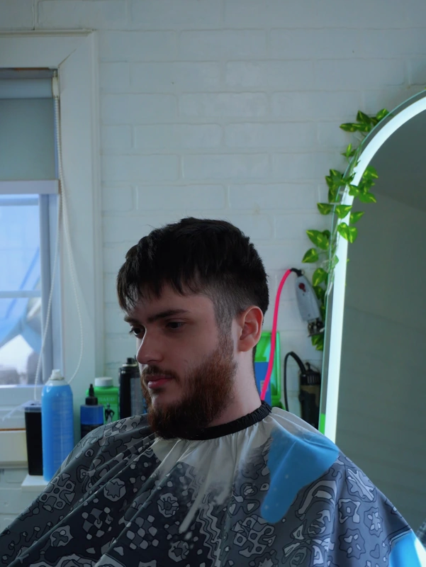 Client before his cut — fringe grown down over the forehead, sides heavy