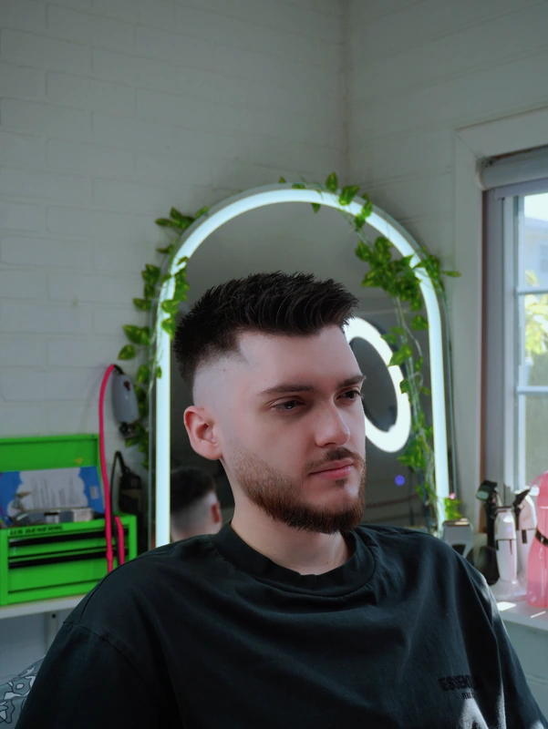 The same client after — textured crop with a skin fade and a sharp line-up
