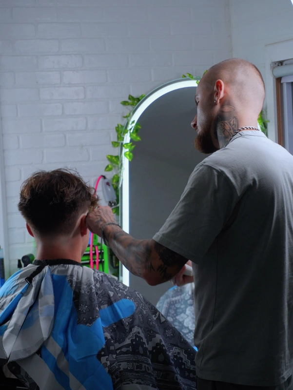 Elvis Krasniqi cutting a client's hair at MisterECuts