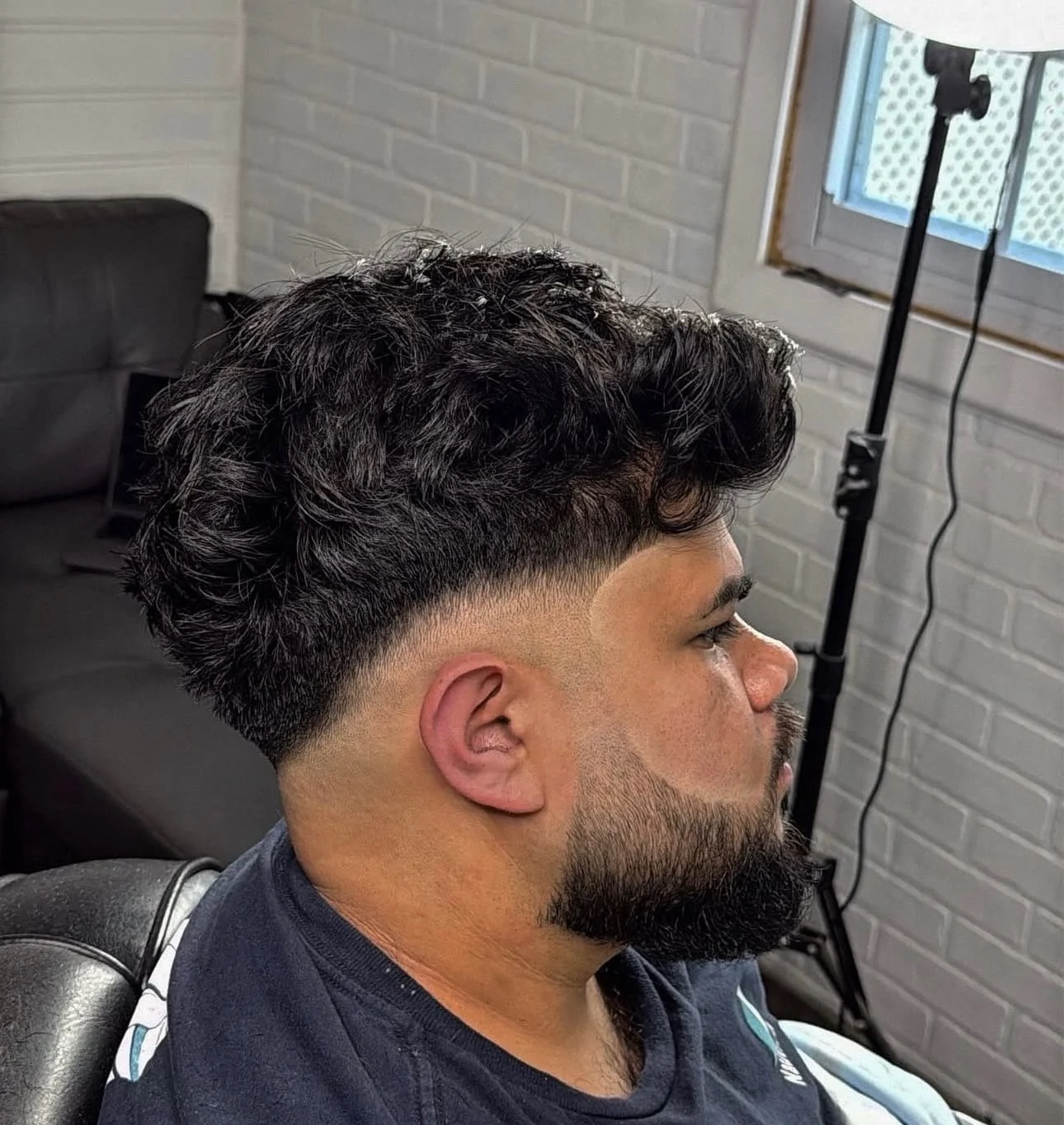 Curly top left long with the sides tapered and the beard shaped and lined in