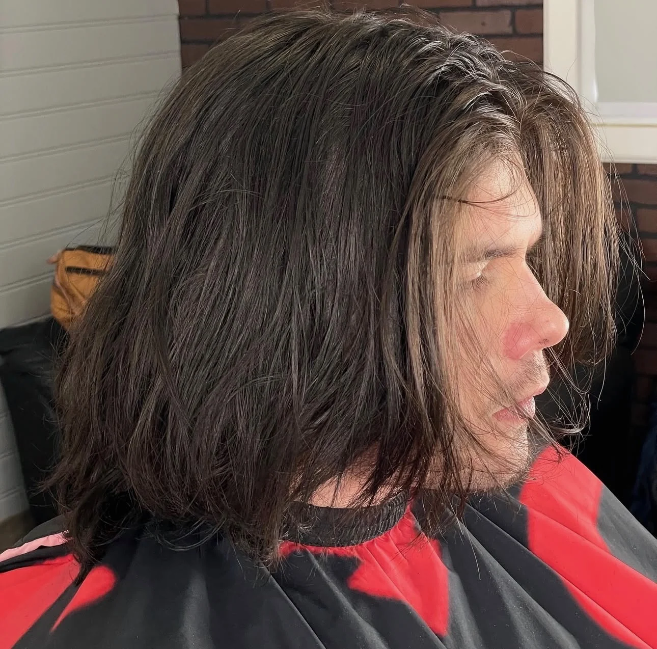 Client before the cut, hair grown past the shoulders